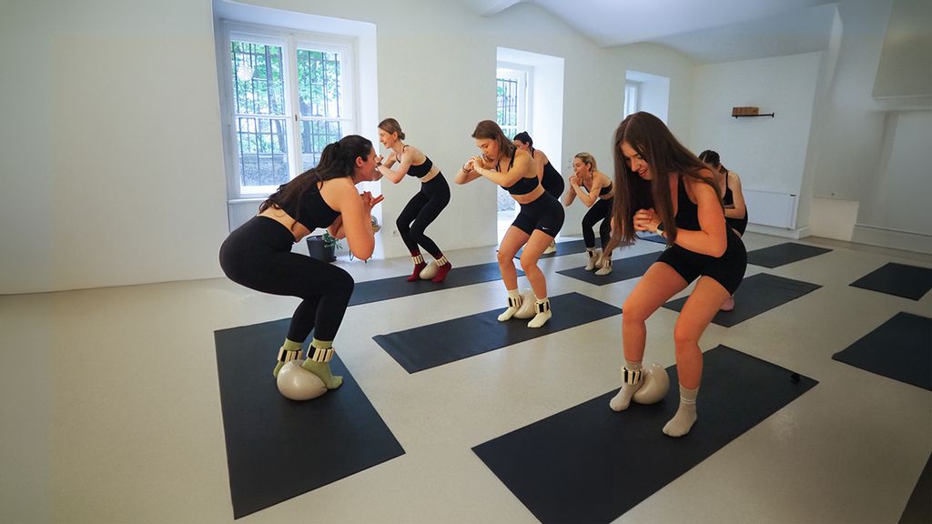 Mehrere Frauen bei Pilates Übungen auf Matten