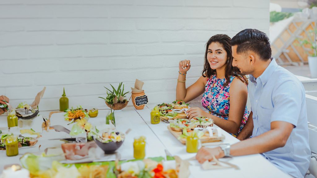 eine Frau und ein Mann sitzen vor einem Tisch mit Essen