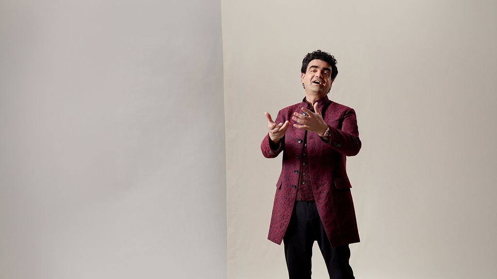 Rolando Villazón singend in dunkelrotem Anzug