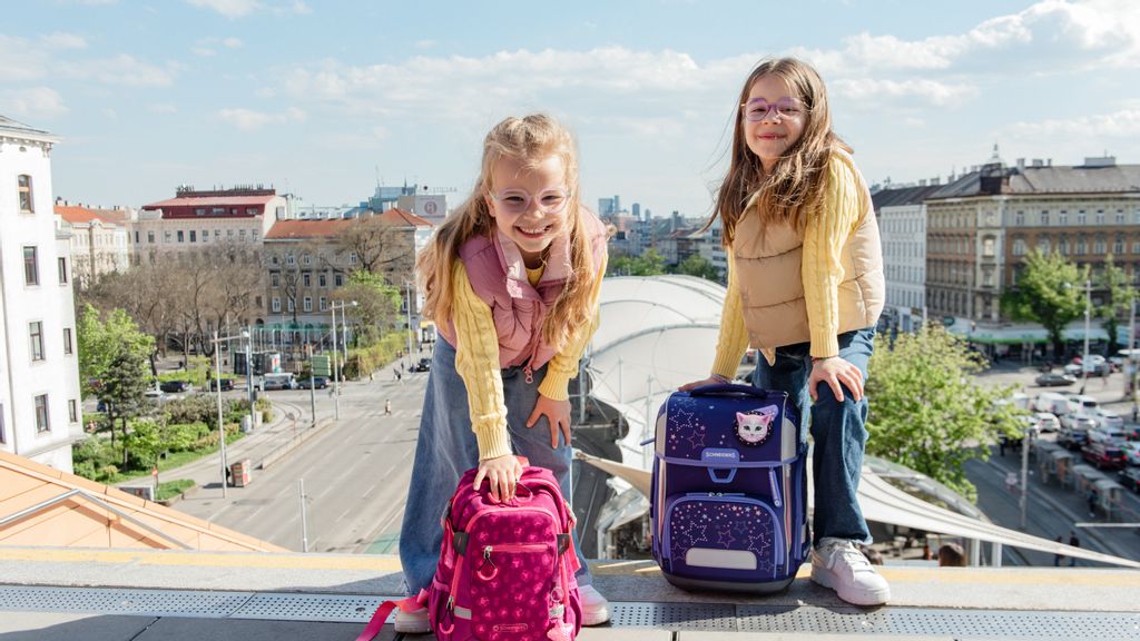 Zwei Mädchen mit Schulrucksäcken auf der Bücherei Wien