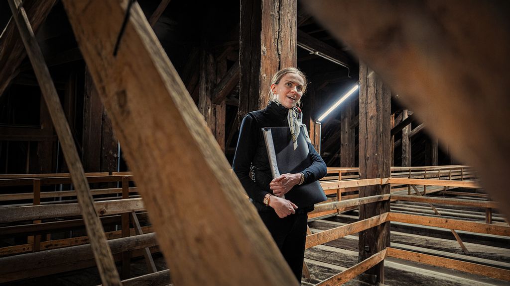 Eine Frau mit Mappe in der Hand im Dachstuhl der Spanischen Hofreitschule