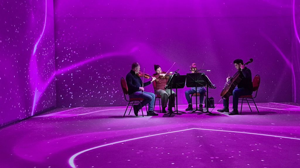 Ein Streichquartett vor immersiver, violetter Kulisse