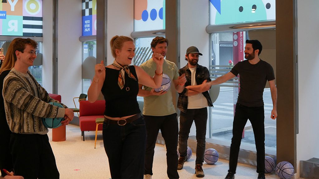 Gruppe von Personen spielt gemeinsam ein interaktives Spiel in einem Innenraum