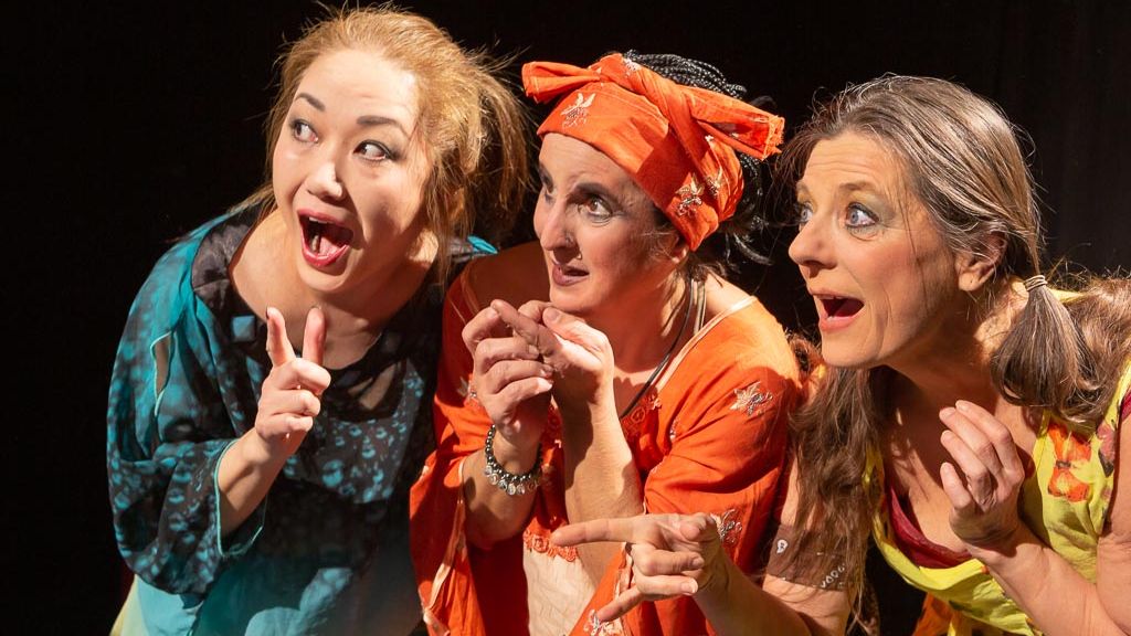 Drei Schauspielerinnen auf der Theaterbühne