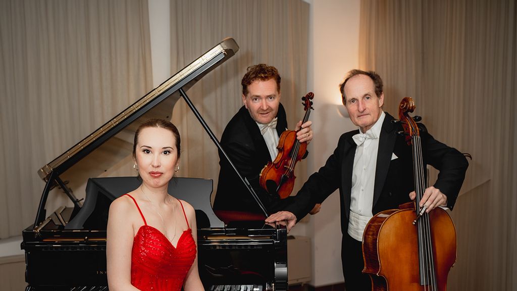 Drei Musiker*innen des Trio Appassionato vor einem Flügel mit Violine und Cello
