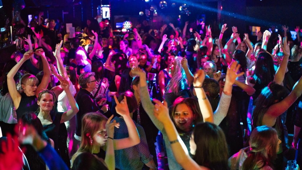 mehrere Frauen tanzend im Club und haben die Hände in die Höhe gehalten