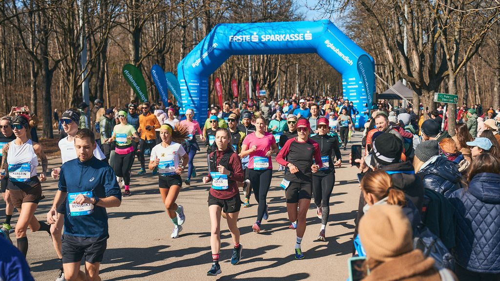© Roman Pfeiffer Läufer*innen bei einem Lauf unter einem blauen Startbogen