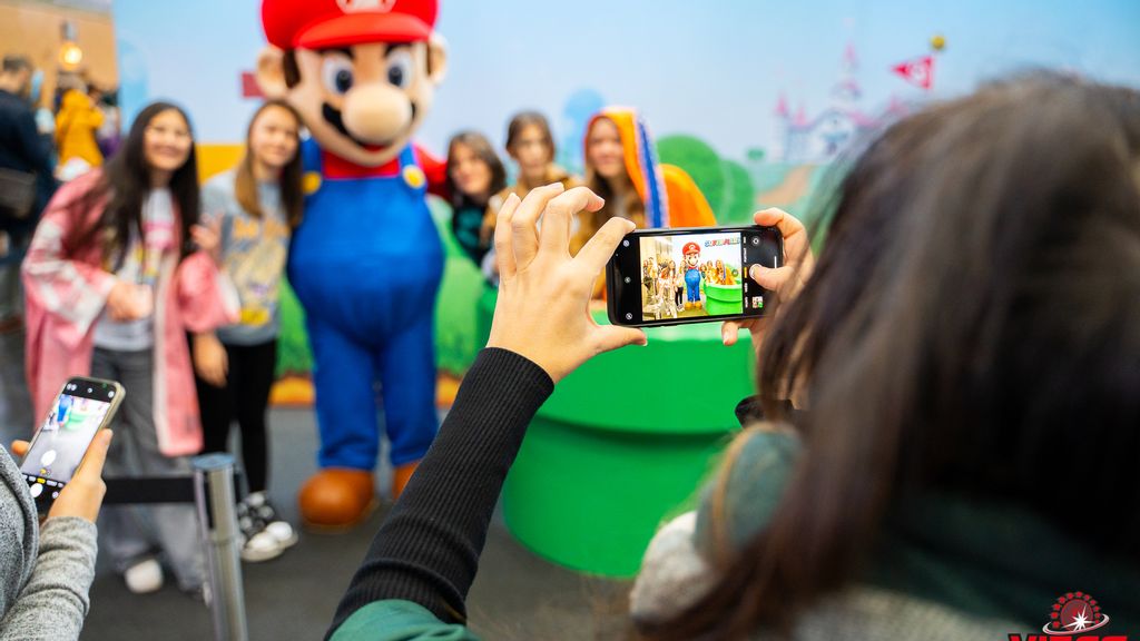 Ein Mädchen fotografiert die Comic-Figur "Super Mario".