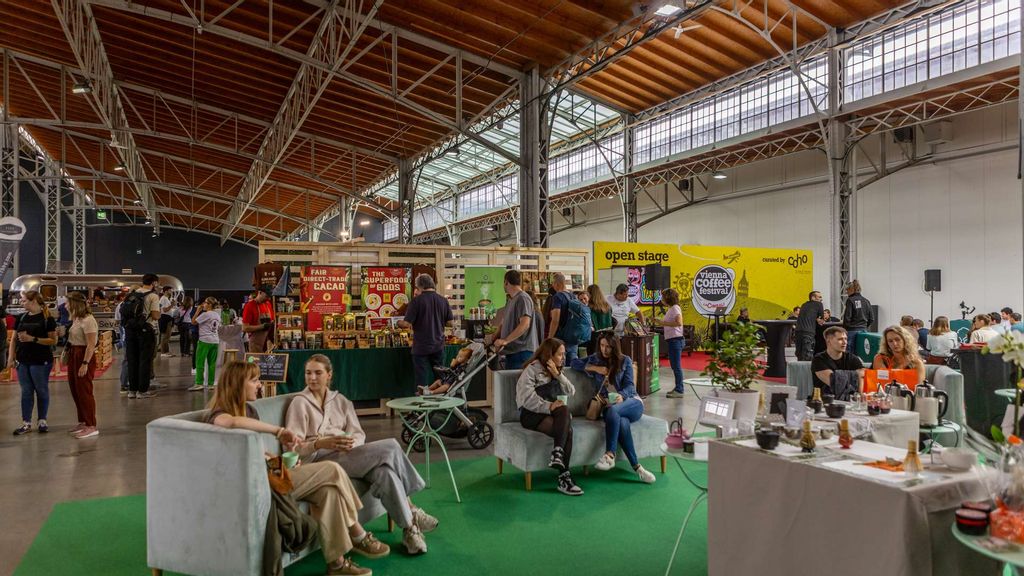 Besucher*innen flanieren durch die Messe und verkosten Kaffee