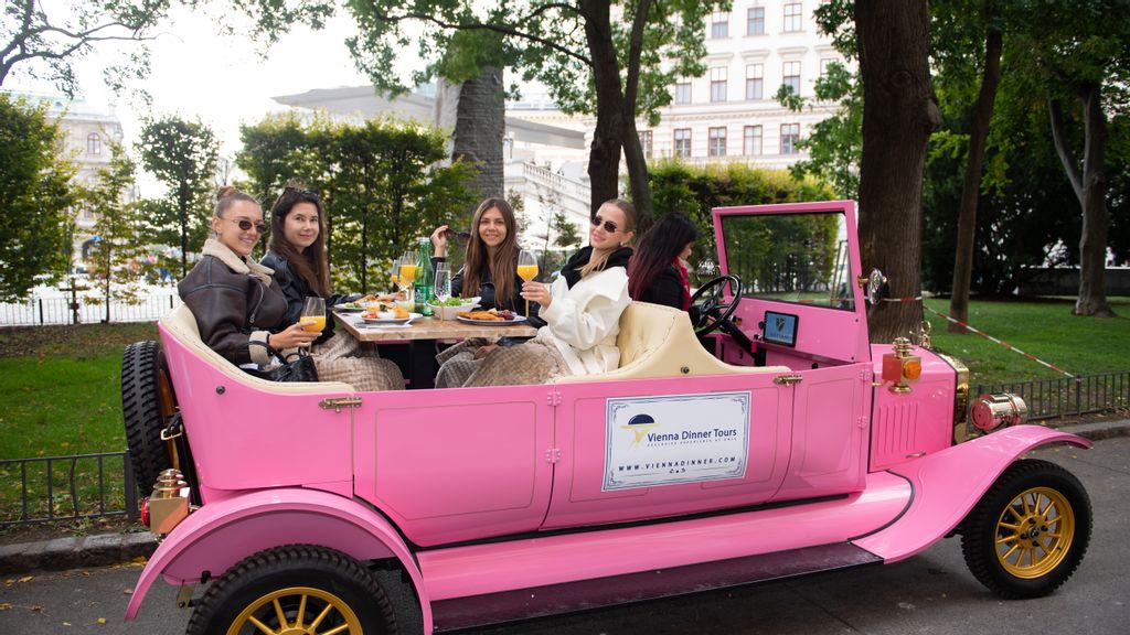 Mehrere Personen sitzen in einem Oldtimer und nehmen bei einer Dinner-Tour teil.