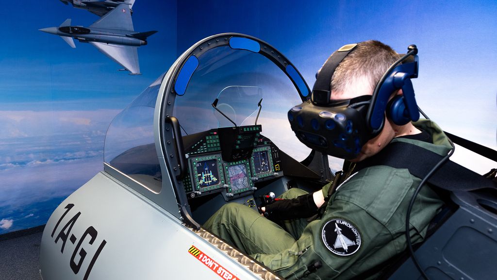 Ein Mann sitzt in einem Flugsimulator mit einer VR-Brille