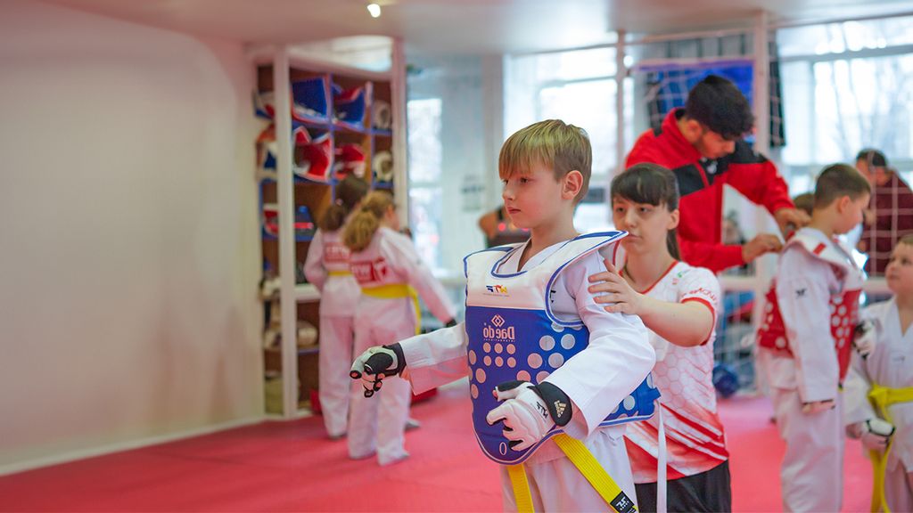Guppe von Kindern im Taekwondo-Outfit auf einer Wiese