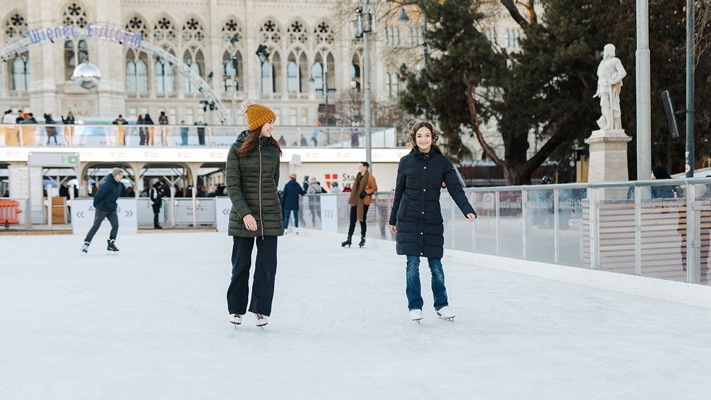 Zwei Frauen die eislaufen vor dem Wiener Rathaus