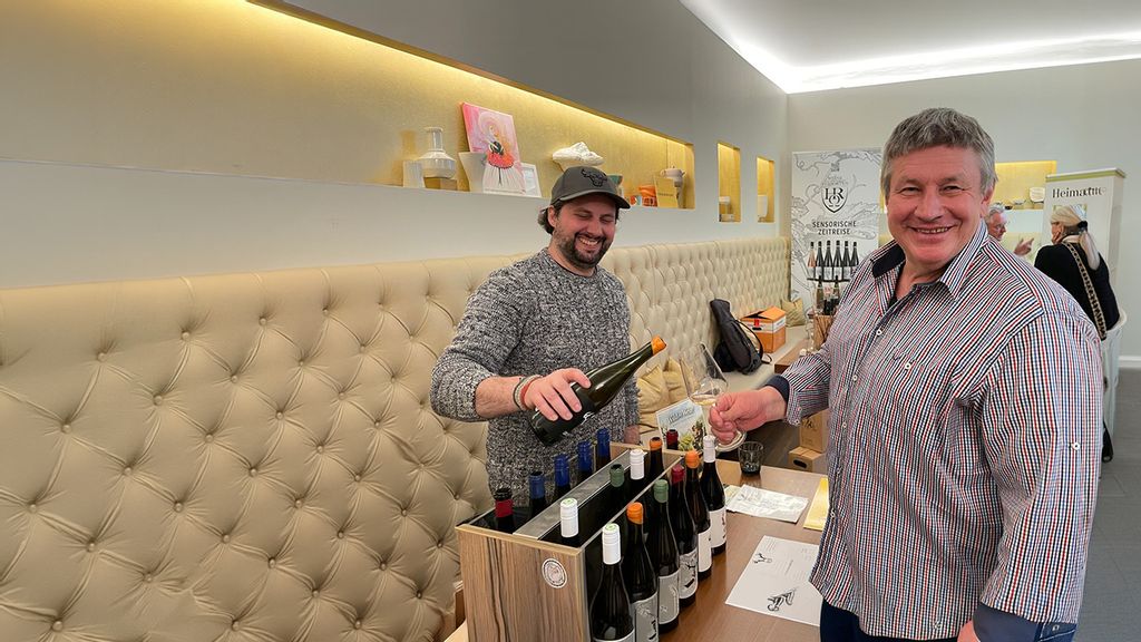 Zwei Personen stehen um einen Stand bei einer Weinverkostung