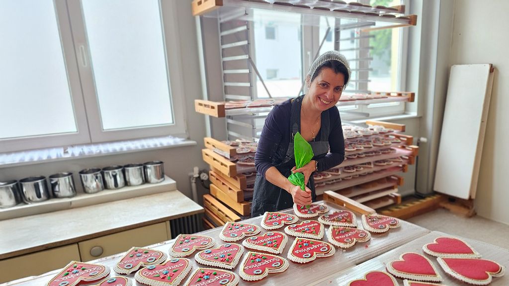 Frau beim Verzieren von Lebkuchenherzen