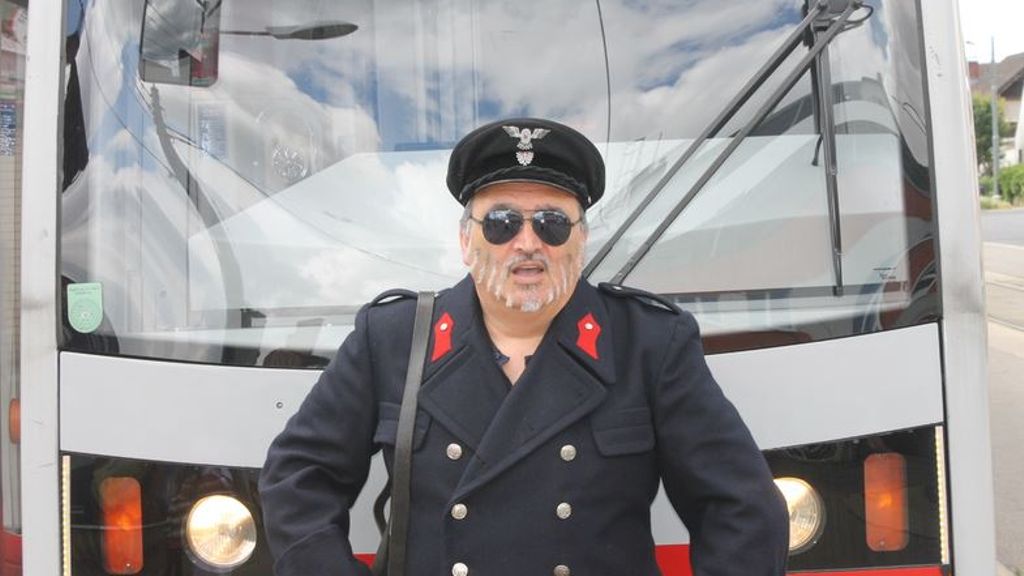 © Karl Friess Mann im Schaffner-Outfit vor einer Straßenbahn