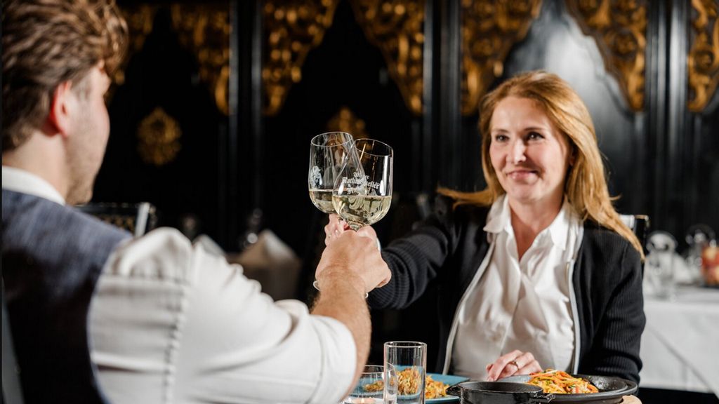 Ein Pärchen sitzt im Rathauskeller und prostet sich zu