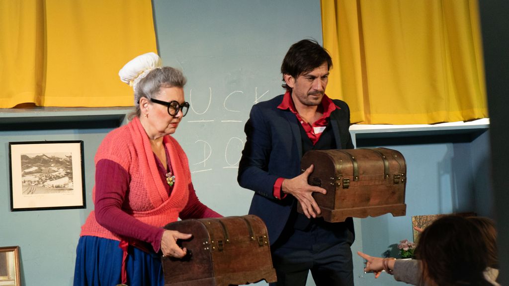Zwei Schauspieler halten jeweils eine Truhe 