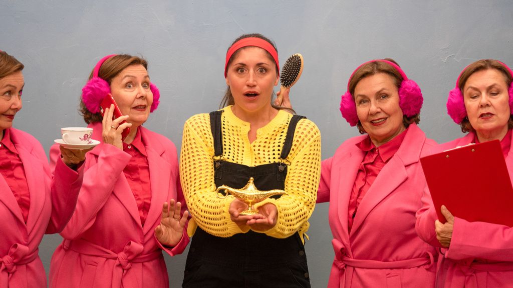 Vier Frauen in rosa Mänteln und eine mit gelbem Pulli und Wunderkerze in der Hand