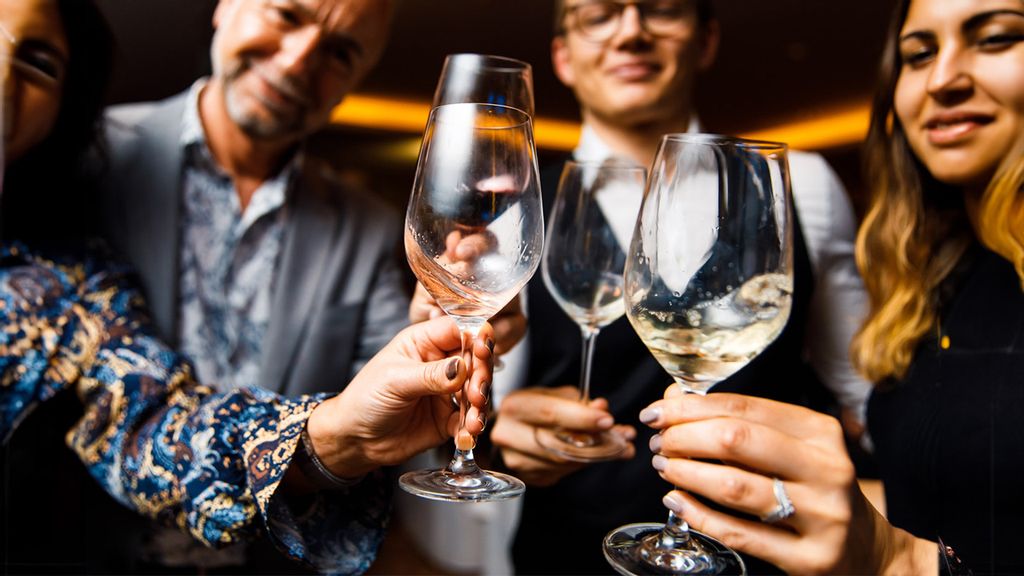 Personen stoßen mit Weingläsern an