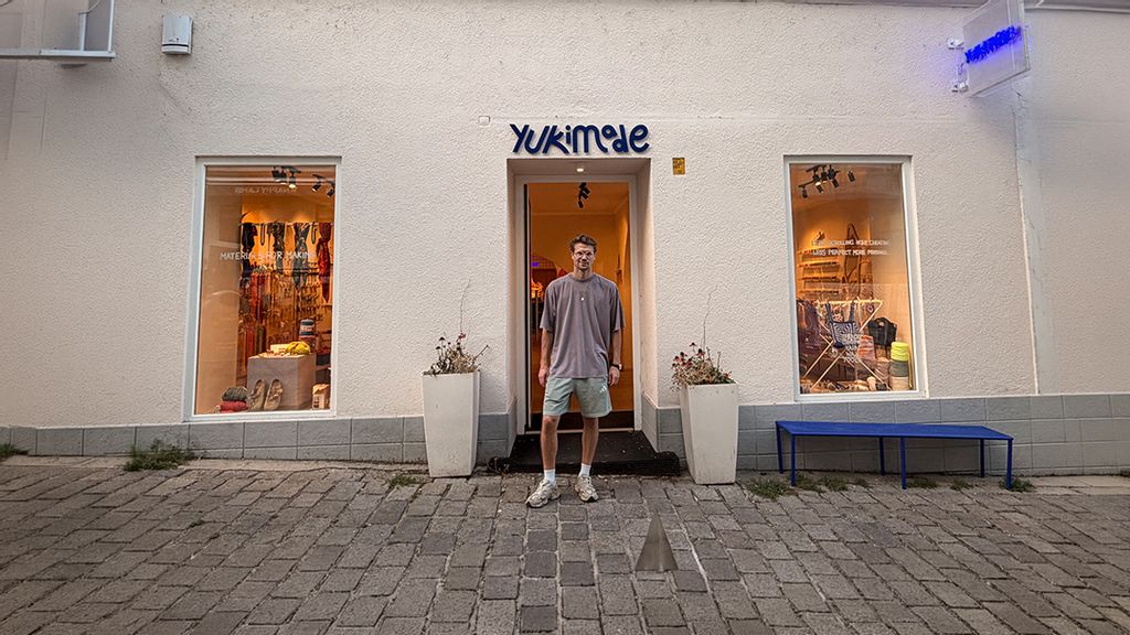 Mann steht vor einem DIY Store in einer Gasse in Wien