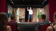 Vier Personen stehen in Kostümen auf einer Bühne und spielen ein Theaterstück