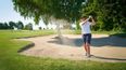 Ein Mann schlägt am Platz des Citygolf Vienna aus einem Bunker
