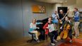 Mehrere Personen musizieren mit unterschiedlichen Instrumenten