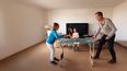 Familie spielt Tischtennis im Wohnzimmer