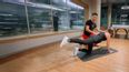 Personaltrainer unterstützt eine Frau beim Training auf der Matte