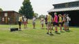 Eine Gruppe an Personen mit einem Golftrainer auf einem Golfplatz