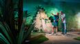 Frau und Mann beim Indoor Minigolf vor einer Maya-Pyramide 
