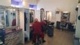 Joel schneidet einer Dame im Salon die Haare.