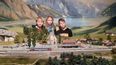 Modellbau mit einer verschneiten Eisenbahnstrecke, Häusern und 3 Kindern als Besucher.