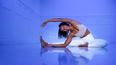 Eine Frau macht Yoga in einem blau beleuchteten Raum