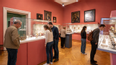 Besucher*innen eines Museums betrachten ausgestellte Stücke
