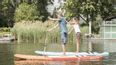 Zwei Personen auf jeweils einem Stand-Up Paddle 