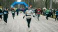 Läufer*innen bei einem Lauf unter einem blauen Startbogen