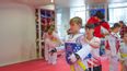 Guppe von Kindern im Taekwondo-Outfit auf einer Wiese