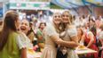 Zwei junge Frauen im Dirndl umarmen sich auf die Wiener Kaiser Wiesn