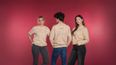 Drei Personen in beigen Sweatshirts von wienliebe vor pinkem Hintergrund