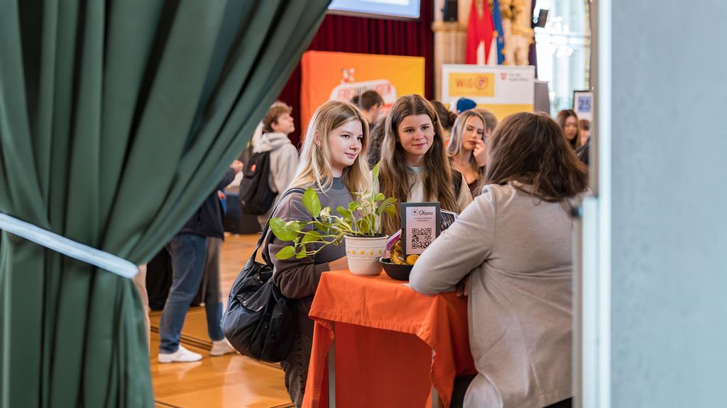 junge Frauen informieren sich bei einem Stand 