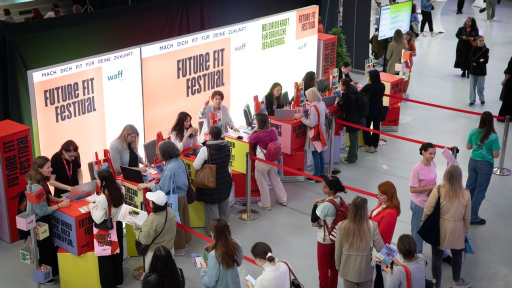 Mehrere Personen, die sich bei einer Messe bei Schaltern anstellen