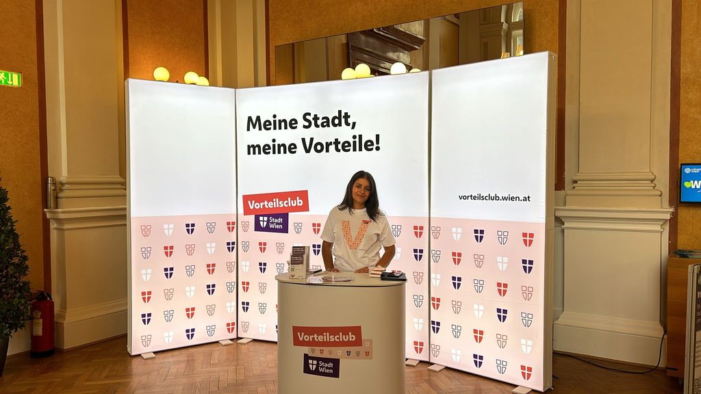 Vorteilsclub Stand mit eine LED Rückwand und einem Info Desk und einer Promotorin
