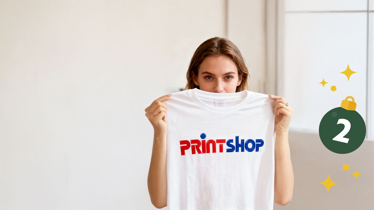 Eine Frau hält ein T-Shirt mit der Aufschrift PRINTSHOP