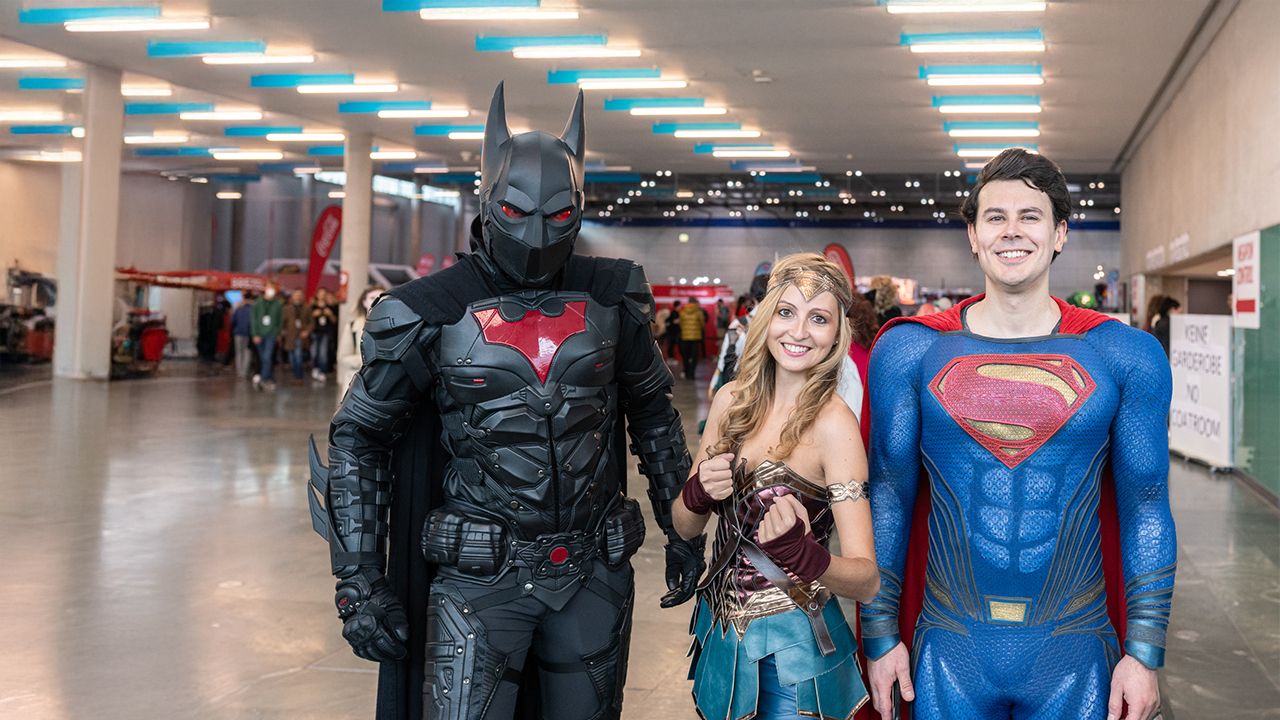 Drei verkleidete Personen als Batman, Wonderwoman und Superman