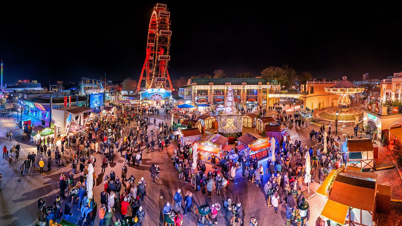 Der Adventmarkt am Riesenradplatz mit bunten Lichtern aus Vogelperspektive