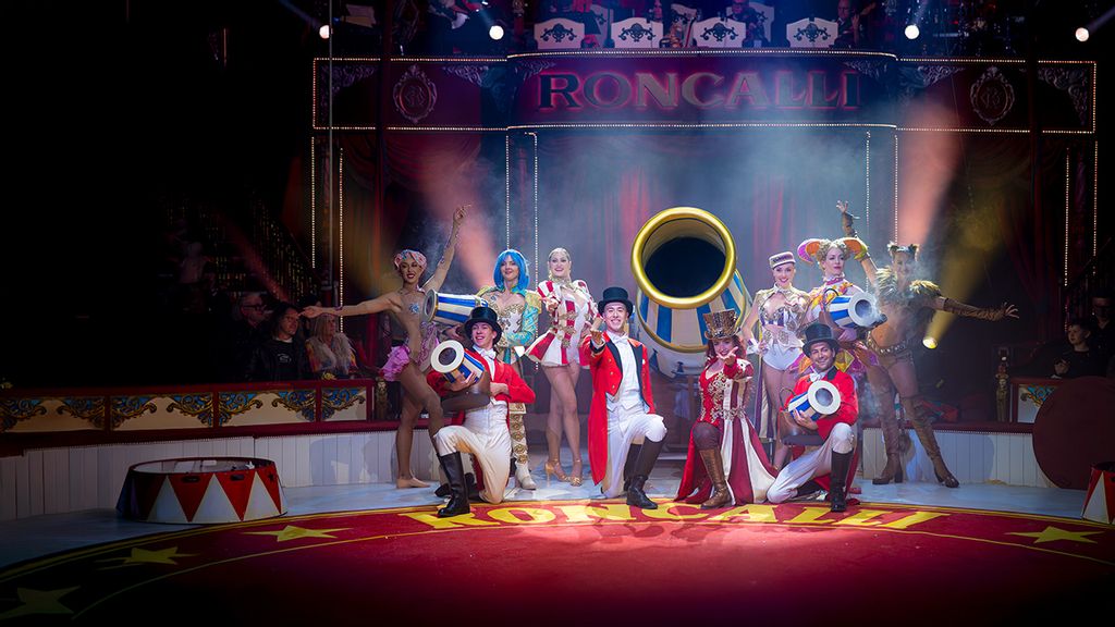 Eine Gruppe Artisten mit Kostümen auf auf einer Bühne im Zirkus
