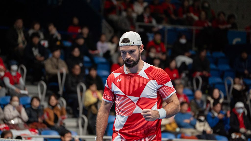 Tennisspieler in rot-weißem Outfit während eines Matches auf dem Court