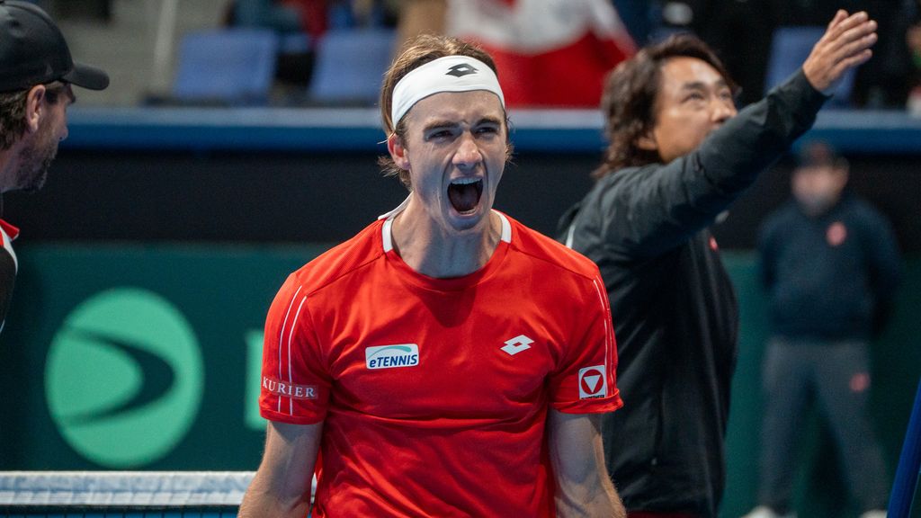 Tennisspieler im roten Outfit jubelt emotional auf dem Tennisplatz